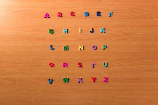 Colored alphabet letters on a wooden background