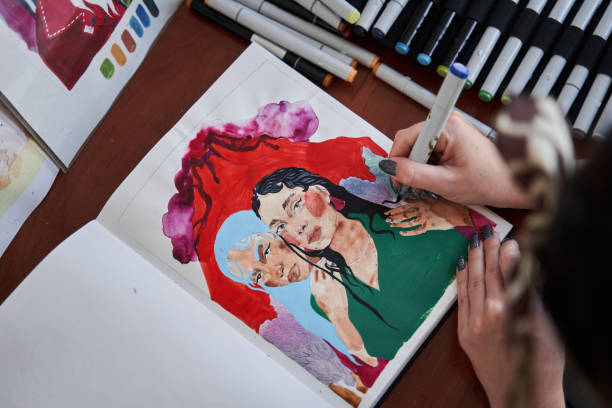 istock Female graphic designer using markers while working at her new art work at the notebook 1411256558