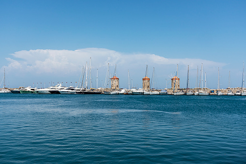 Mandraki marina with three windmills, one of the most famous symbols of Rhodes Island. Mooring place for small yachts in summer.