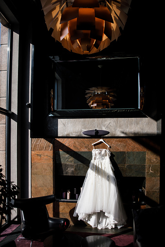 Wedding dress hanging on a stone wall.