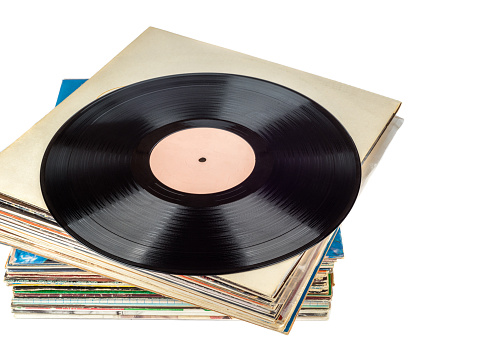 Stack of records in a package and one disc on top of the stack. Copy space, white background.