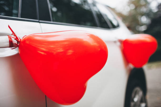 Wedding car decorated with balloons on the door.