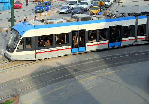 Istanbul, Turkey / Türkiye: tram / light rail - Sirkeci - traffic waits for the train to pass at the corner of Ankara Cd and Ragip Gümüspala Cd - Bombardier Flexity Swift A32 - operated by Metro Istanbul - Istanbul Metropolitan Municipality / Istanbul Büyüksehir Belediyesi.