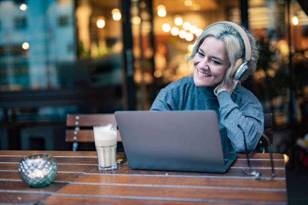 istock Woman whit headphones using laptop in cafe 1411265919