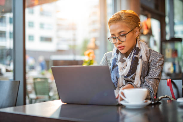 istock Young woman using laptop in coffee bar 1411266809