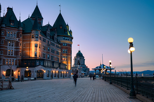 People walking on Dufferin terrace at dusk, close to Château Frontenac hotel, Quebec city, QC, Canada