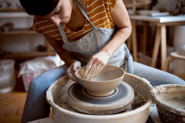 istock Caucasian female potter, working on pottery wheel 1411271311