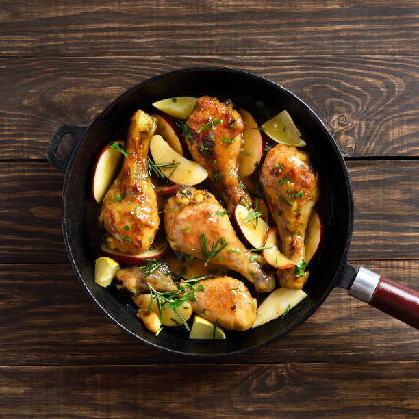 chicken drumsticks baked with apples and herbs - chicken thighs imagens e fotografias de stock