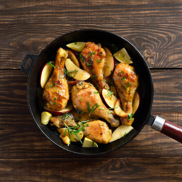 baquetas de frango assadas com maçãs e ervas - chicken thighs - fotografias e filmes do acervo