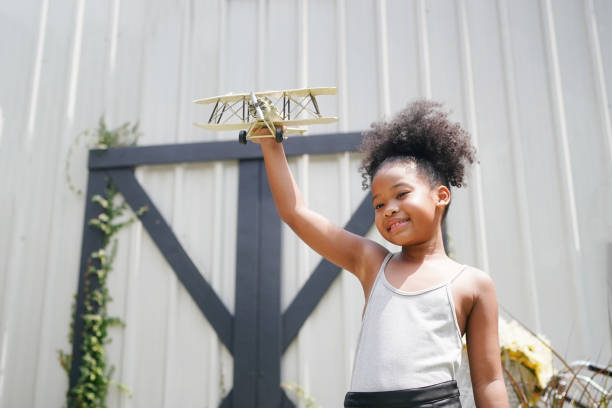 istock Young girl playing with toy airplane 1411271499