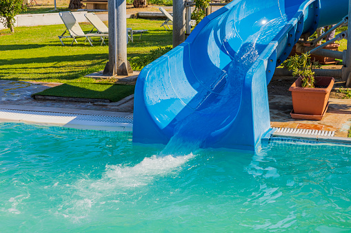 Close up view of blue waterslide at hotel outdoor pool.