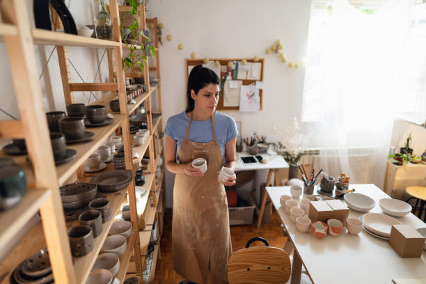 istock Female potter organizing pottery products in her studio 1411272485