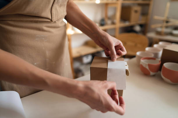 istock Unrecognizable small business owner, using recyclable material for pottery packaging 1411272600