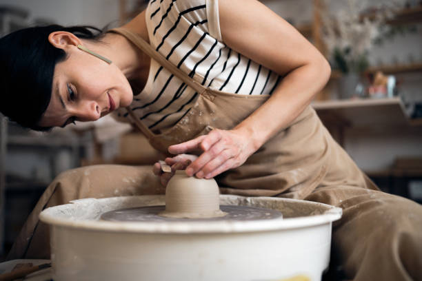istock Young woman making pottery in her art studio 1411272664
