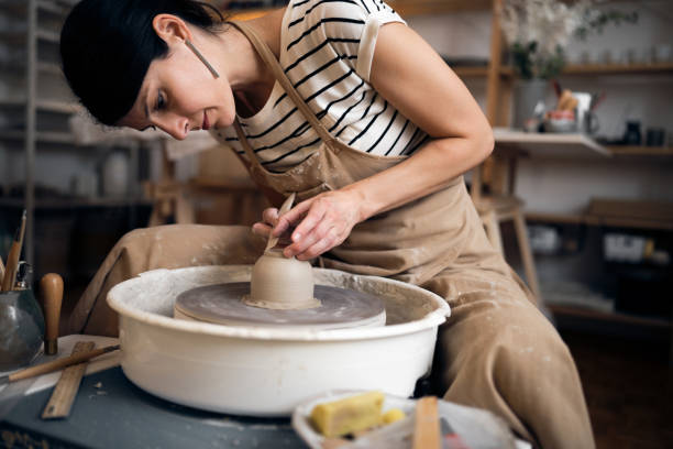 istock Young Caucasian woman working with a pottery wheel in her workshop 1411272709