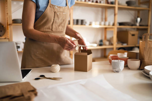 istock Unrecognizable small business owner, using recyclable material for pottery packaging 1411272936