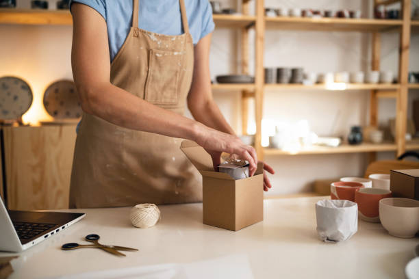 istock Unrecognizable small business owner, using recyclable material for pottery packaging 1411272939