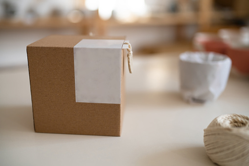 Close up of carboard package, on the desk at the pottery studio