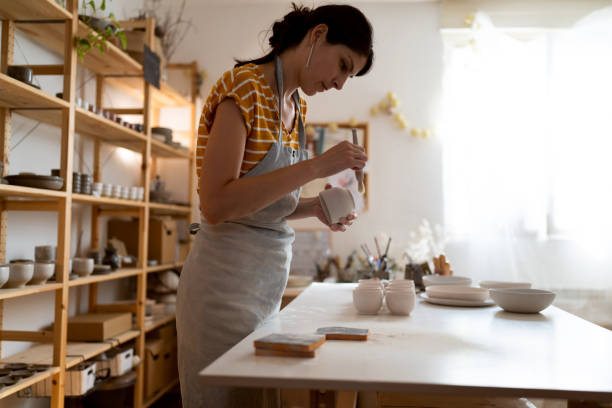 istock Young female potter, using sandpaper to polish the pottery 1411273749