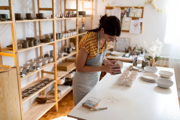 istock Female potter, using sandpaper to polish the pottery 1411273808