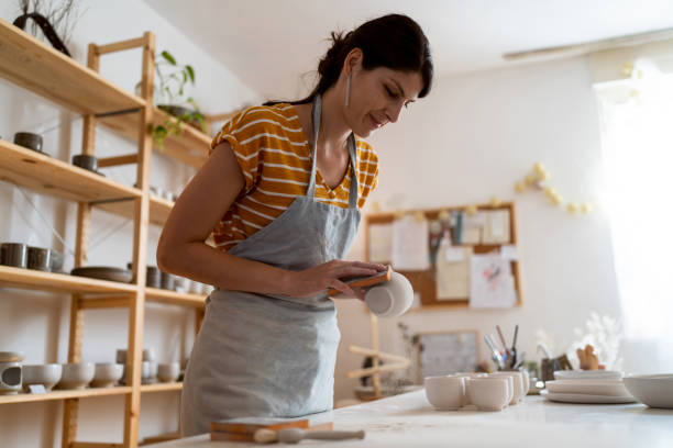istock Female potter, using sandpaper to polish the pottery 1411273811