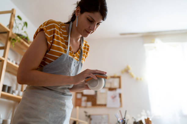 istock Female potter, using sandpaper to polish the pottery 1411273823