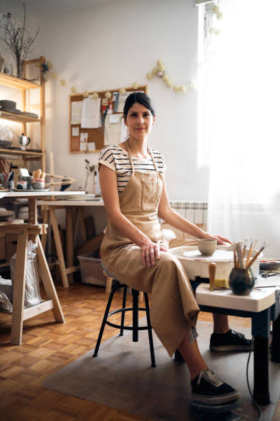 Portrait of a female potter entrepreneur in her studio Portrait of a potter entrepreneur in her studio. artist sculptor stock pictures, royalty-free photos & images