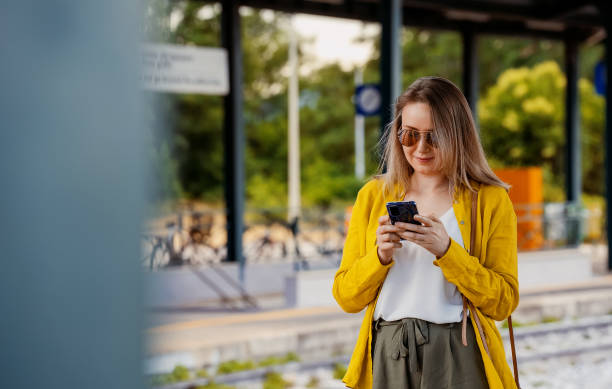 istock Woman with smartphone is waiting for her train. 1411274642