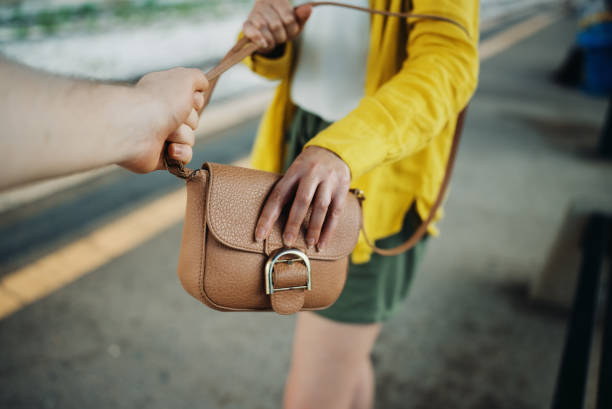 istock Thief robs a woman's handbag at the train station. 1411274719