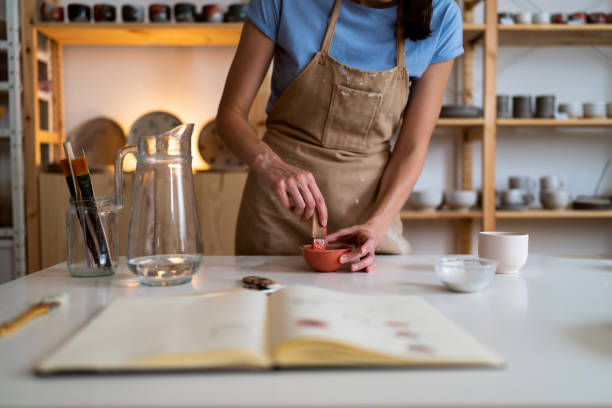 istock Caucasian female potter mixing the paint 1411275410