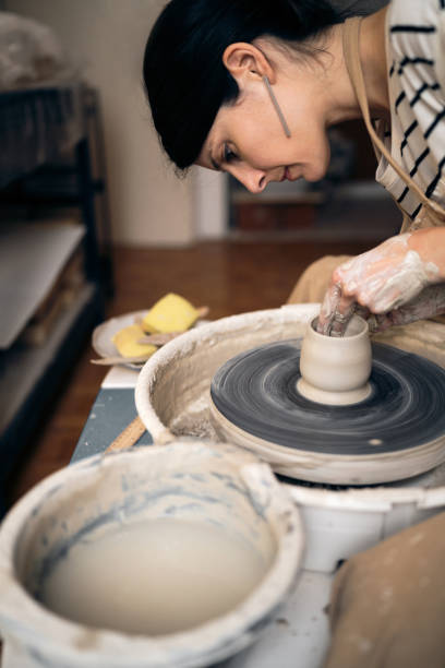 istock Young woman working with a pottery wheel in her workshop 1411275486