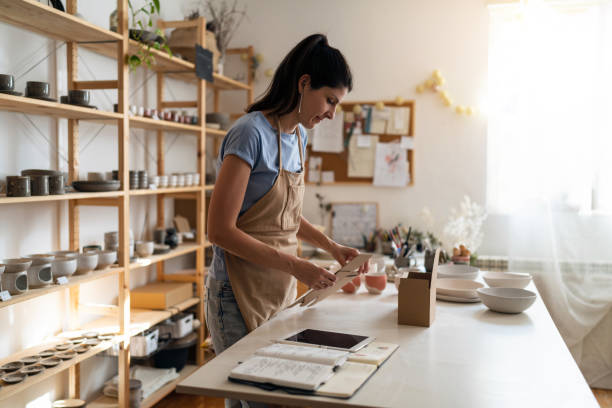 istock Female small business owner, assembling carboard box for packaging 1411275580