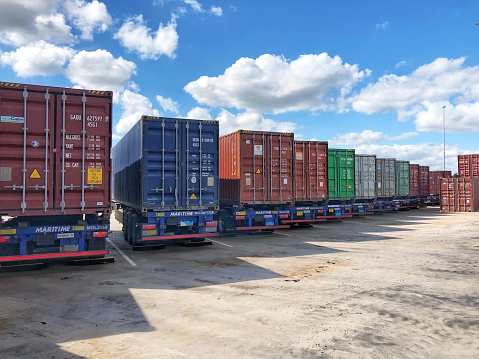 East Midlands Gateway, UK - July 4, 2022.  A row of shipping containers loaded onto trailers for road transportation