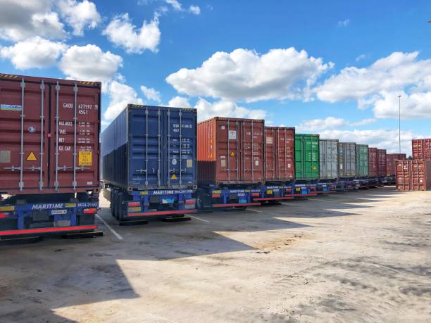 A row of shipping containers loaded onto trailers for road transportation East Midlands Gateway, UK - July 4, 2022. A row of shipping containers loaded onto trailers for road transportation container stock pictures, royalty-free photos & images
