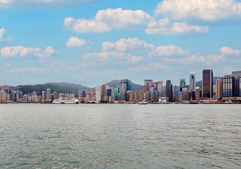 Hong Kong, China - April 27, 2017: Famous Hong Kong island skyline with tall skyscrapers shot from Kowloon during sunny day