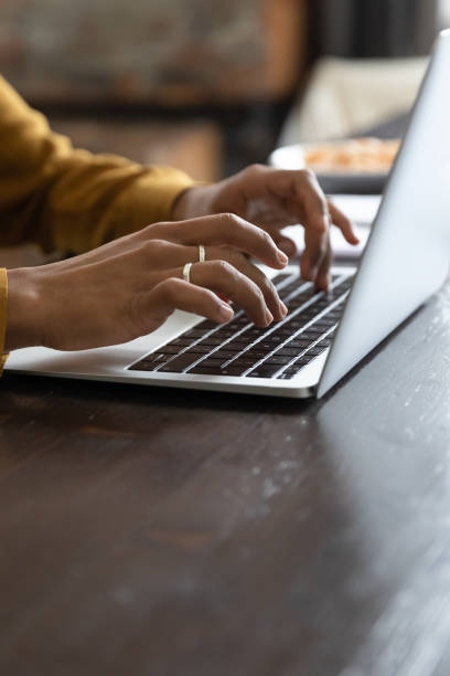 Closeup vertical view African female hands typing on laptop keyboard
