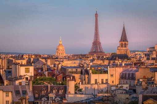 Eiffel tower and parisian roofs at golden sunrise Paris, France