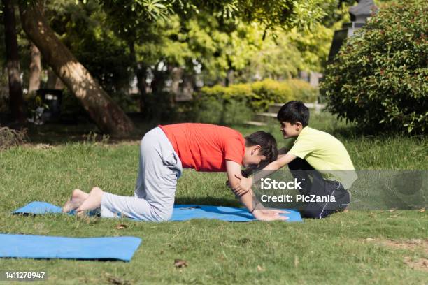 Kids Practices Yoga And Meditating Outdoors In Lawn Or Park Or Nature In Springtime Beginner Meditation Healthy Lifestyle Concept Stock Photo - Download Image Now