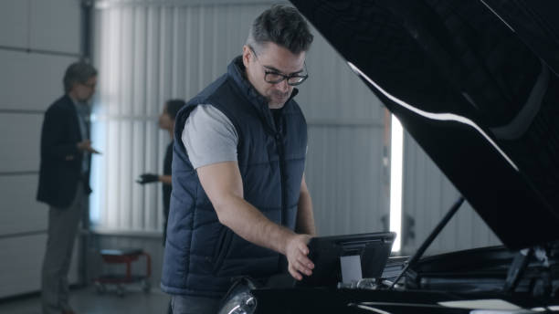istock Male mechanic inspecting car engine 1411279547