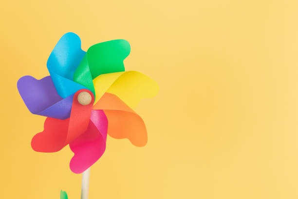 istock Coloured pinwheel on yellow background. Copy space. 1411282368