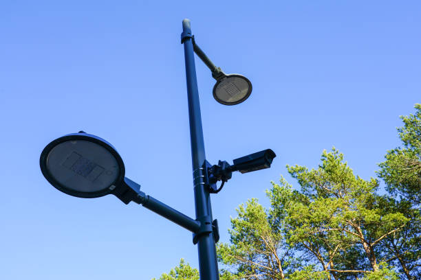 nowoczesne wyposażenie infrastruktury parkowej, lampy ledowe i kamera systemu monitoringu na metalowym słupie - mounted guard zdjęcia i obrazy z banku zdjęć