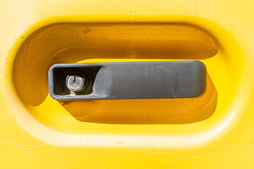 door handle on a construction site vehicle with clear signs of use on the lock