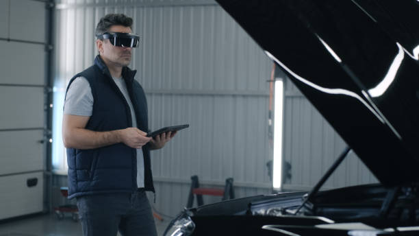 istock Mechanic checking a car in VR headset 1411283487