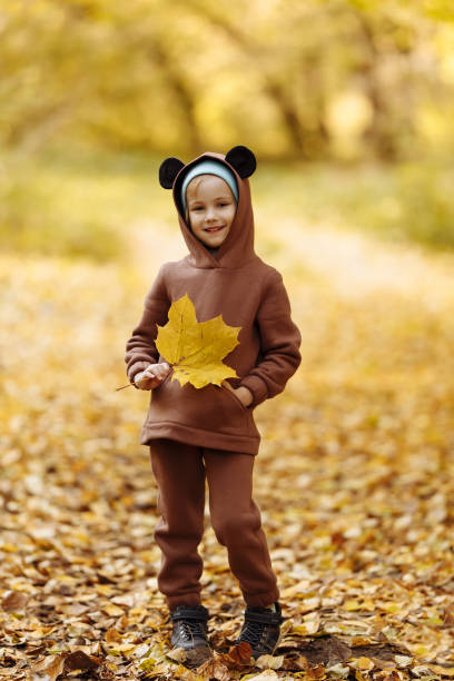 istock Girl with a maple leaf in her hands 1411283840