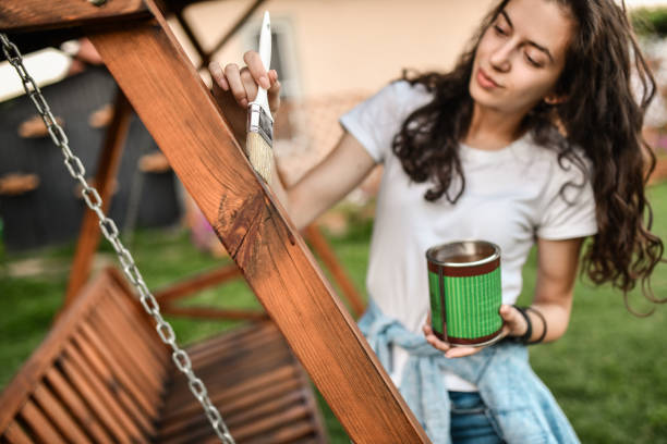 istock Female Doing Professional Painting Work On Backyard Swing 1411285338