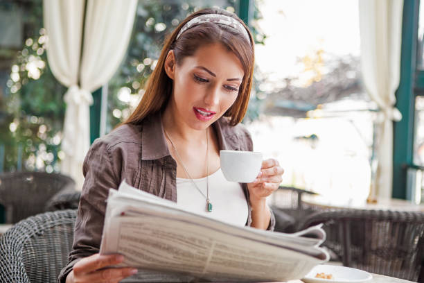 istock Drinking coffee and reading newspaper at cafe 1411286354