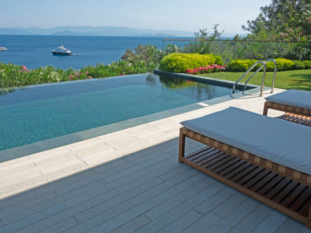 istock Deck chairs on Wooden plank floor against swimming pool 1411286372