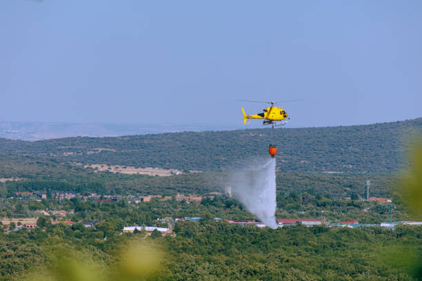istock A yellow firefighting helicopter putting out a fire by dropping water. 1411288677