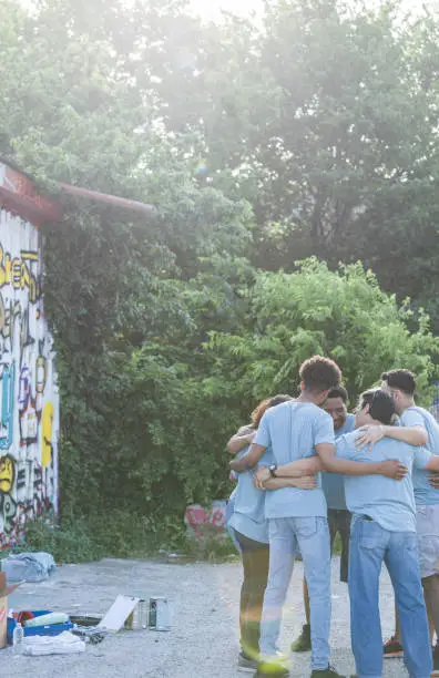 Photo of Volunteers stand near the graffiti wall