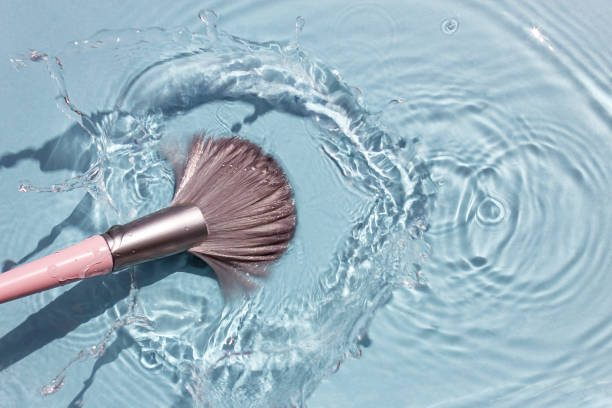 Makeup brush in clean water with a splash. Summer cosmetics concept. Makeup brush in clean water with a splash. Summer cosmetics concept. Top view. make up brush stock pictures, royalty-free photos & images